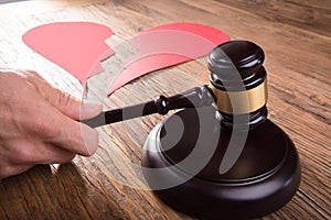 Divorce Judge With Broken Heart At Desk Hitting Gavel