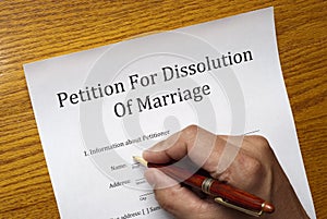 Divorce papers with hand and pen