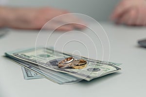 Divorce property. Money and wedding rings on the table.