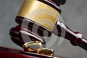 Divorce and separation concept. Two golden wedding rings and judge gavel