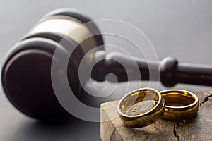 Divorce and separation concept. Two golden wedding rings, judge gavel.