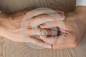 Divorce, separation: hands of man removing wedding or engagement ring
