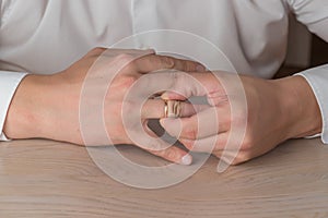 Divorce, separation: man removing wedding or engagement ring
