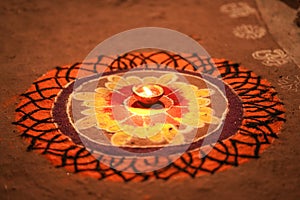 Diwali celebration - Diya oil lamps lit on colorful rangoli, Indian festival diwali and colourful rangoli and diya in centre