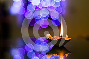Diwali earthen lamp on the foreground of beautifully illuminated lights