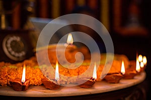 Diwali glowing Diya and flowers arranged in circular shape forming a design with copy space, selective focus with extra white