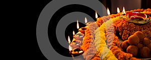 Diwali glowing Diya , flowers, Sweets and Gifts arranged in circular shape forming a design with copy space, selective focus ,
