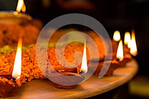 Diwali glowing Diya , flowers, Sweets and Gifts arranged in circular shape forming a design with copy space, selective focus ,