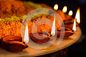 Diwali glowing Diya , flowers, Sweets and Gifts arranged in circular shape forming a design with copy space, selective focus ,