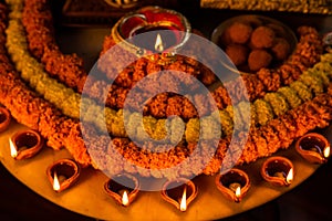 Diwali glowing Diya , flowers, Sweets and Gifts arranged in circular shape forming a design with copy space, selective focus ,