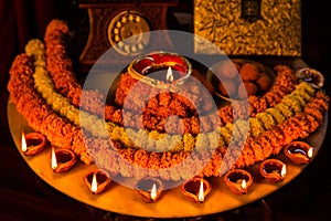 Diwali glowing Diya , flowers, Sweets and Gifts arranged in circular shape forming a design with copy space, selective focus ,