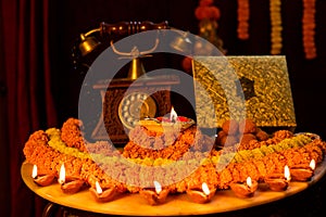 Diwali glowing Diya , flowers, Sweets and Gifts arranged in circular shape forming a design with copy space, selective focus ,