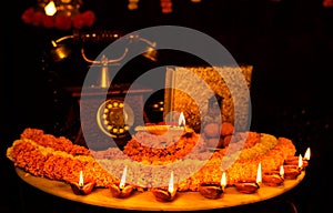 Diwali glowing Diya , flowers, Sweets and Gifts arranged in circular shape forming a design with copy space, selective focus ,