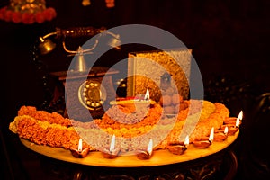 Diwali glowing Diya , flowers, Sweets and Gifts arranged in circular shape forming a design with copy space, selective focus ,