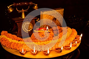 Diwali glowing Diya , flowers, Sweets and Gifts arranged in circular shape forming a design with copy space, selective focus ,