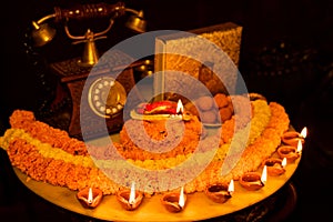 Diwali glowing Diya , flowers, Sweets and Gifts arranged in circular shape forming a design with copy space, selective focus ,
