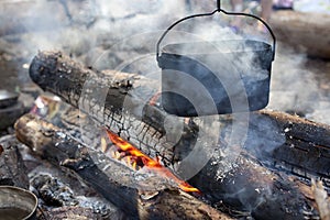 A dixy on the fire is on stones in the forest