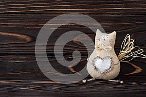 DIY, cat toy on wooden background. Hand made kitty with heart from textile. Dark wood natural boards, text space. Romantic card,