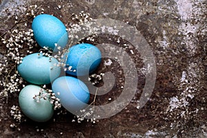 DIY dyed various shades of blue Easter eggs on retro rusty metal background. Happy Easter.