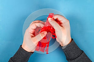 Diy Easter egg basket made of red plastic cup decorated with artificial flowers on blue background