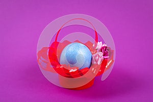 Diy Easter egg basket made of red plastic cup decorated with artificial flowers purple background