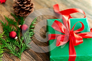 DIY Gift Wrapping. Beautiful green christmas gifts with red bow on rustic wooden table. Top view.