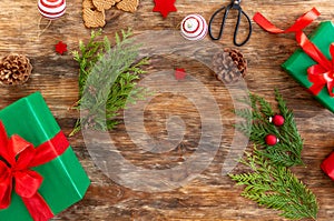 DIY Gift Wrapping. Beautiful green christmas gifts with red bow on rustic wooden table. Top view.