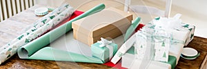 DIY Gift Wrapping. Beautiful nordic christmas gifts on wooden table. Christmas wrapping station banner.