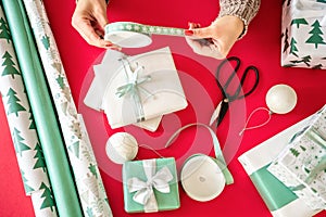 DIY Gift Wrapping. Unrecognisable woman wrapping beautiful nordic style christmas gifts. Hands close up. photo