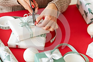 DIY Gift Wrapping. Unrecognisable woman wrapping beautiful nordic style christmas gifts. photo