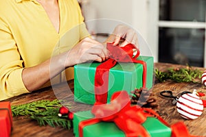 DIY Gift Wrapping. Unrecognisable woman wrapping beautiful red and green christmas gift boxes.