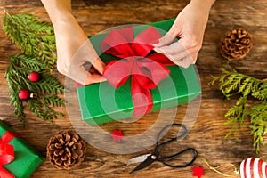 DIY Gift Wrapping. Woman wrapping beautiful christmas gifts on rustic wooden table. Overhead view christmas wrapping. photo
