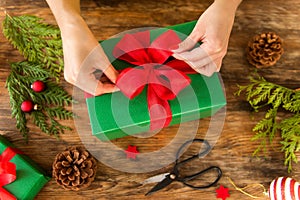 DIY Gift Wrapping. Woman wrapping beautiful christmas gifts on rustic wooden table. Overhead view christmas wrapping.