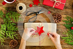 DIY Gift Wrapping. Woman wrapping beautiful red christmas gifts on rustic wooden table. Overhead view christmas wrapping.