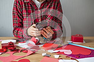 DIY holiday card with red paper heart, symbol of love. Girl  makes Mother`s Day, Valentine`s Day, greeting card. Hobby,  art