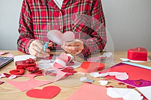 DIY holiday card with red paper heart, symbol of love. Girl  makes Mother`s Day, Valentine`s Day, greeting card. Hobby,  art