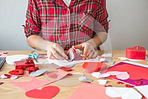 DIY holiday card with red paper heart, symbol of love. Girl  makes Mother`s Day, Valentine`s Day, greeting card. Hobby,  art