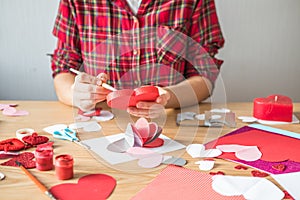 DIY holiday card with red paper heart, symbol of love. Girl  makes Mother`s Day, Valentine`s Day, greeting card. Hobby,  art