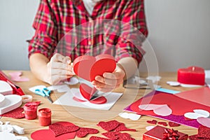 DIY holiday card with red paper heart, symbol of love. Girl  makes Mother`s Day, Valentine`s Day, greeting card. Hobby,  art