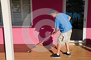 DIY home owner painting staining wooden deck photo