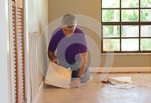 DIY homeowner man or professional installing vinyl tile flooring