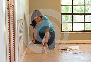 DIY homeowner woman or professional installing vinyl tile flooring