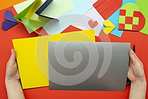 DIY instruction. The process of making a paper heart from yellow and gray colored paper for Valentine's Day