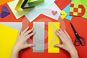 DIY instruction. The process of making a paper heart from yellow and gray colored paper for Valentine\'s Day