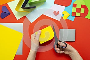 DIY instruction. The process of making a paper heart from yellow and gray colored paper for Valentine\'s Day