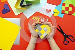 DIY instruction. The process of making a paper heart from yellow and gray colored paper for Valentine's Day