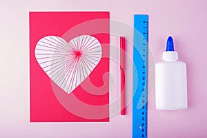 DIY and kid`s creativity. Step by step instruction: how to make valentine greeting card with heart. Step4 glue heart with stripes
