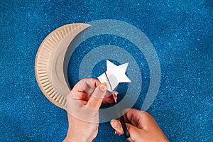 Diy Ramadan kareem crescent moon with a star from a disposable cardboard plate and gold paint