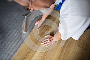 Senior landlord lying parquet floor board/laminate flooring in a rental appartement photo