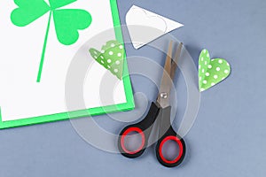 Diy St Patricks Day greeting card made cardboard and paper clovers gray background. Gift idea, decor